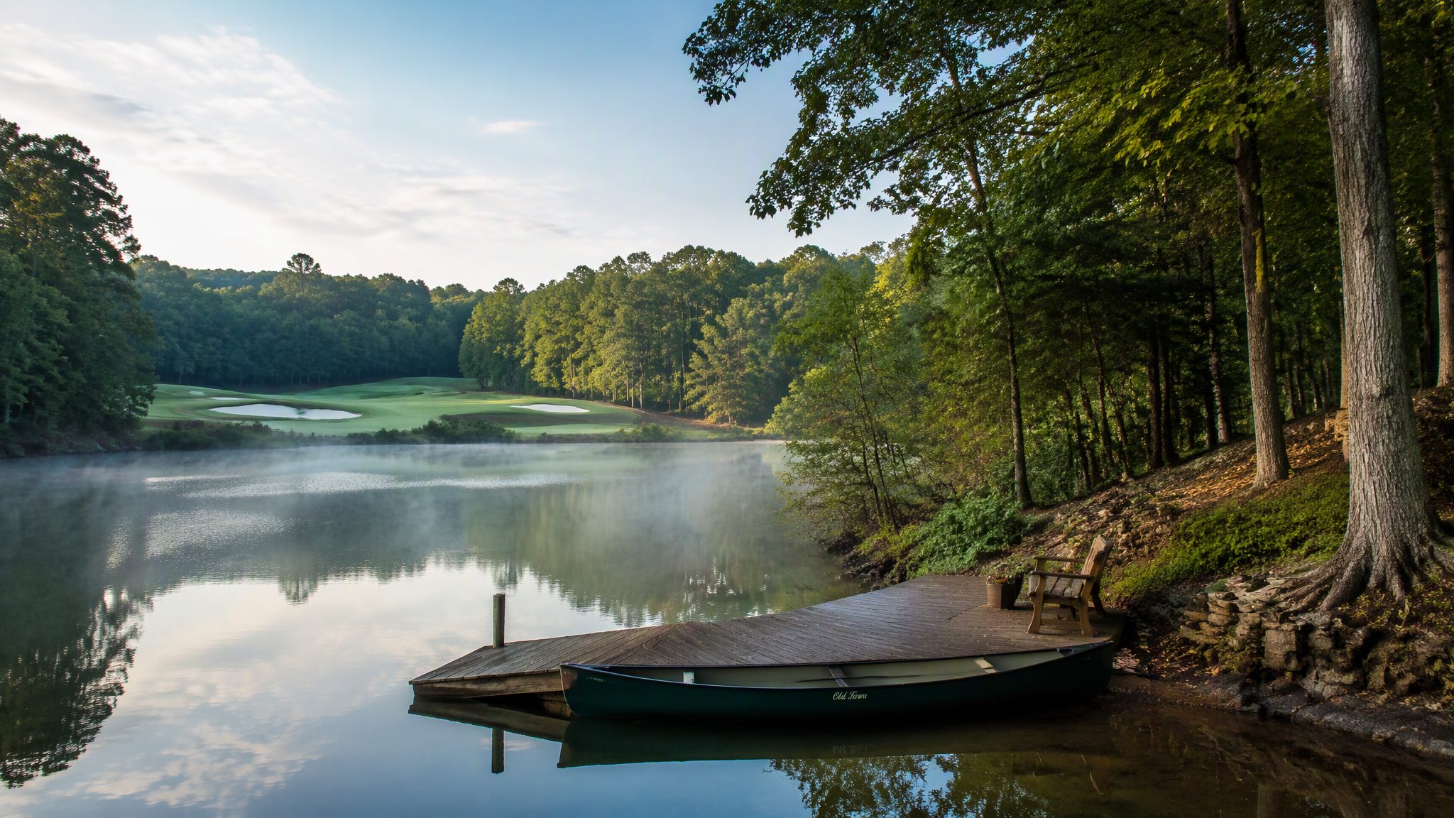 Misty lake cove and golf course green at sunrise in Bella Vista, Arkansas